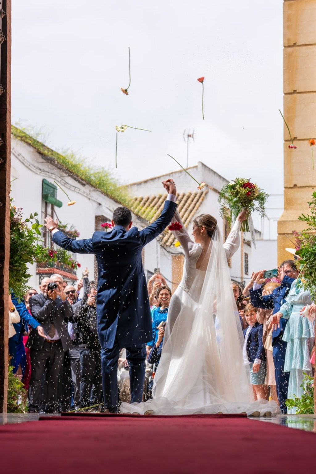 Couple leaving their ceremony among flower petals